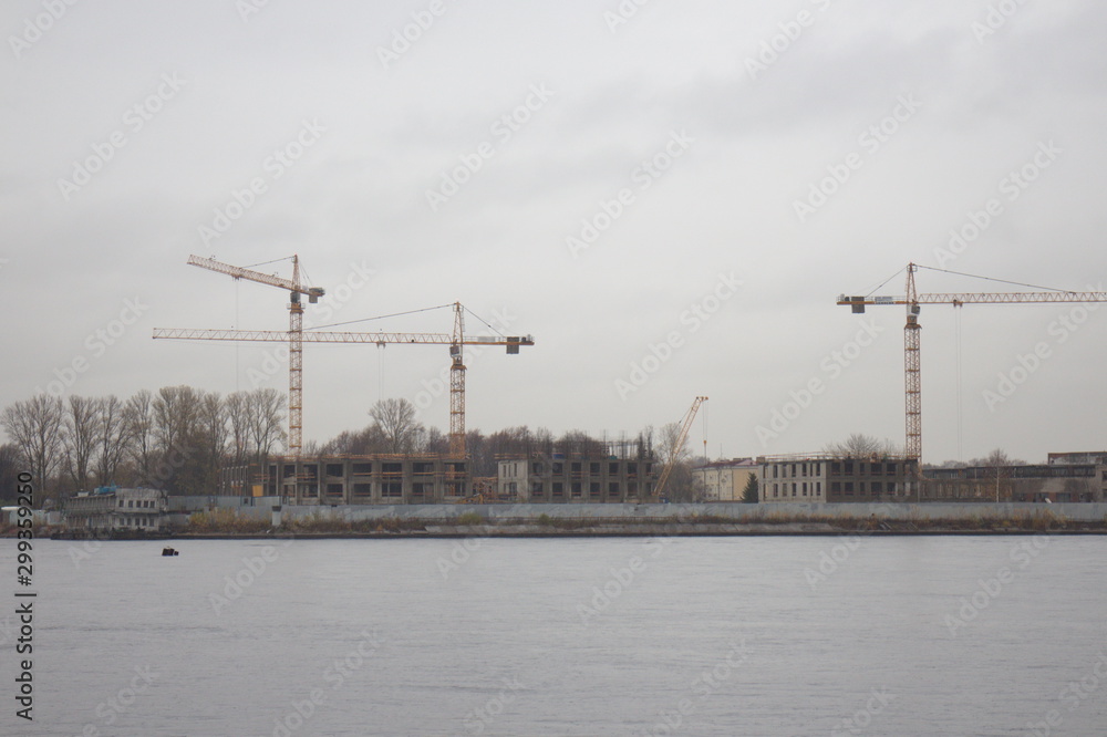 tower cranes on the shore on a cloudy day tower cranes on the shore on a cloudy day
