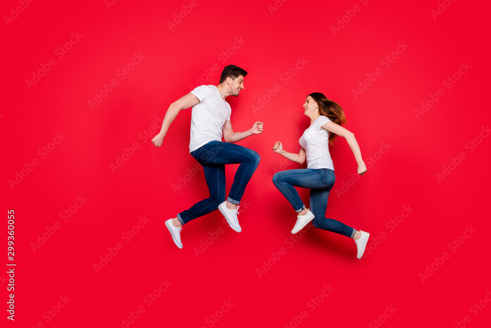 Side profile full body size photo of cheerful nice cute couple of girlfriend boyfriend bumping into each other smiling running jumping jeans denim white t-shirt isolated vivid color background