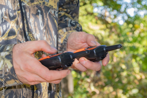 Portable radios in human hands and on clothing items