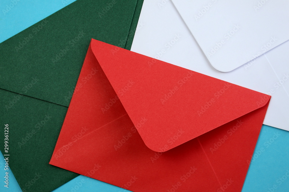 red, green, white envelopes lie on a blue background red, green, white envelopes lie on a blue background