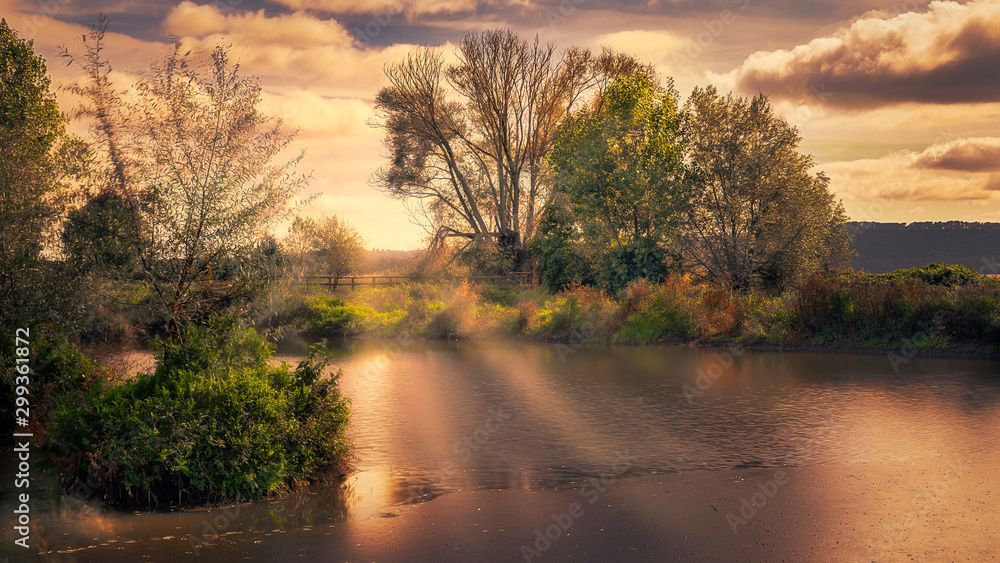 Obraz premium light rays sunset lake