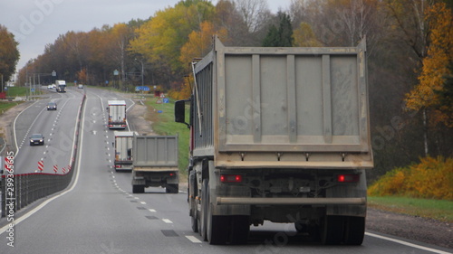 Transportation of bulk materials  heavy empty truck dump truck drive on autumn country road  transport business