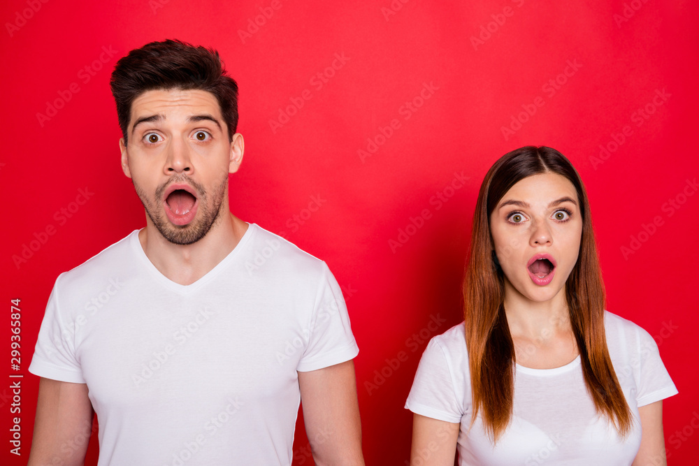 Photo of scared atonished couple of friends afraid of fake bad news spreading with mouth open wide expressing fear on faces with stubble on male face white t-shirt isolated vivid color background - obrazy, fototapety, plakaty 