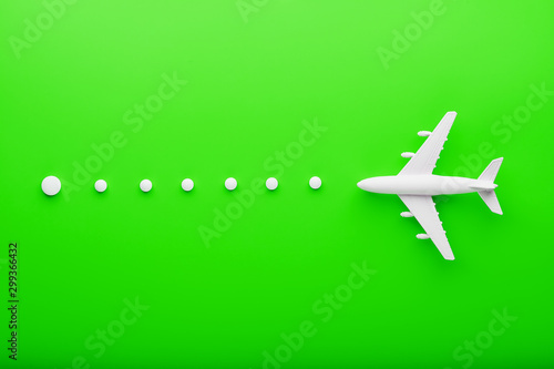 White passenger plane with trajectory points as on a route map, isolated with a bright green background. © Alexander