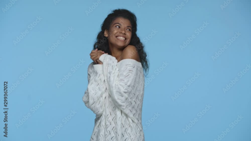 shy smiling african american woman flirting and blowing kiss isolated on blue shy smiling african american woman flirting and blowing kiss isolated on blue