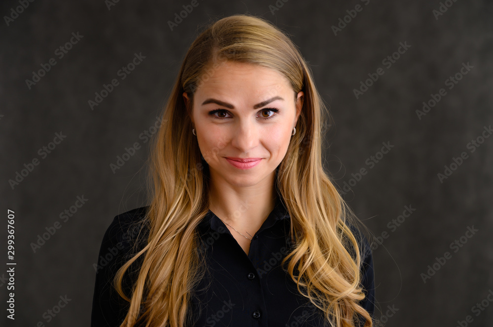 Close-up portrait of a pretty blonde girl with long curly hair standing in the studio on a gray background with emotions in different poses. Beauty, Model, Cosmetics Close-up portrait of a pretty blonde girl with long curly hair standing in the studio on a gray background with emotions in different poses. Beauty, Model, Cosmetics