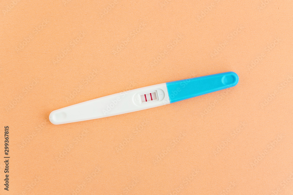 Positive pregnancy test on orange background. Planning of pregnancy, trying to have baby. Positive pregnancy test on orange background. Planning of pregnancy, trying to have baby.