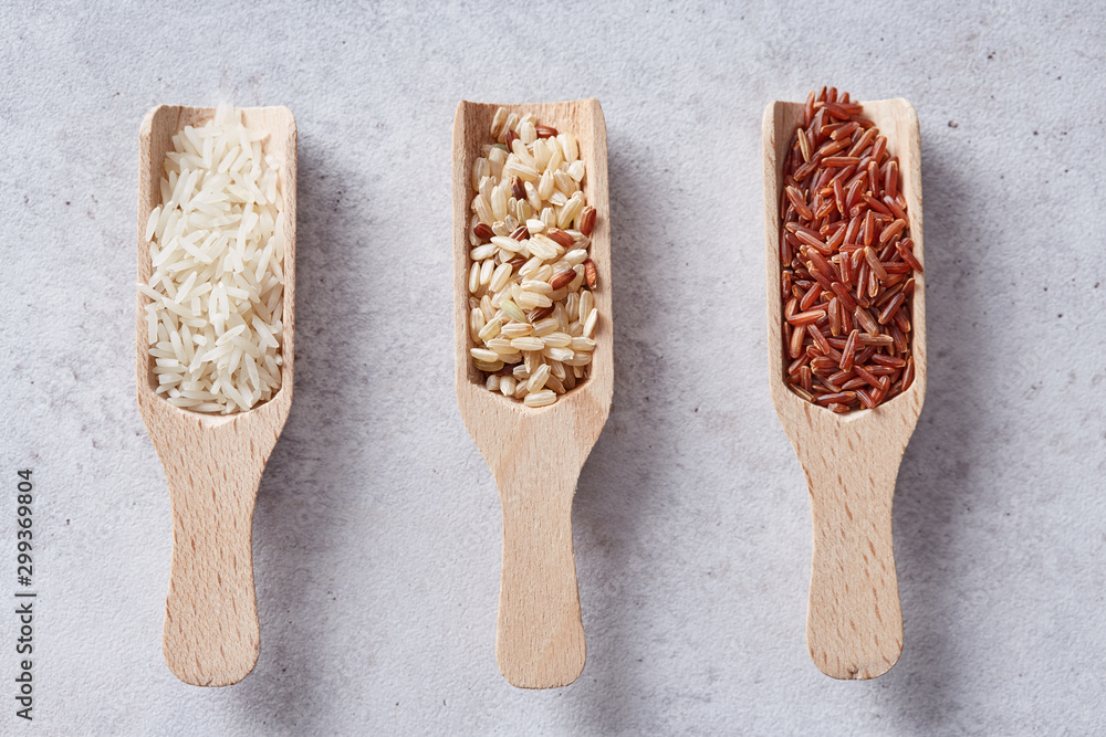 Rice variety in a various wooden spoons. Wild red rice, brown rice ...