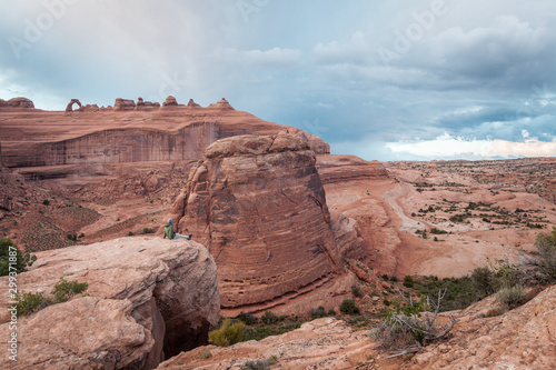 Man sitting on the edge of a rock in Arches Park, Utah