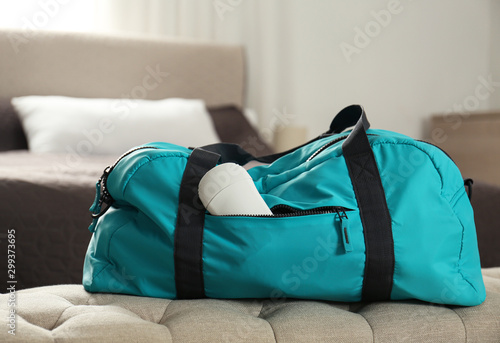 Packed gym bag with deodorant in bedroom photo
