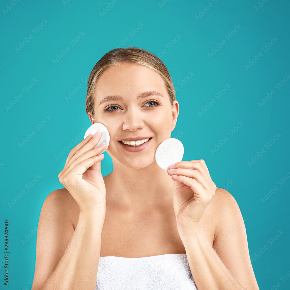 Beautiful young woman with cotton pads on turquoise background Beautiful young woman with cotton pads on turquoise background