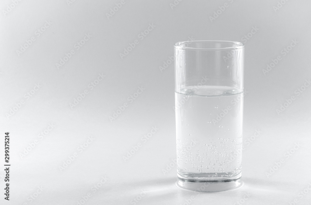 Soda water in a glass. Isolated on white background. A long clear glass tumbler. Health concept, the benefits of drinking water in the morning prolongs life and cures diseases. Copy spase Soda water in a glass. Isolated on white background. A long clear glass tumbler. Health concept, the benefits of drinking water in the morning prolongs life and cures diseases. Copy spase