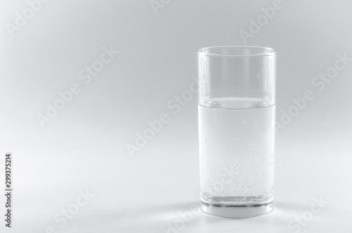 Soda water in a glass. Isolated on white background. A long clear glass tumbler. Health concept, the benefits of drinking water in the morning prolongs life and cures diseases. Copy spase