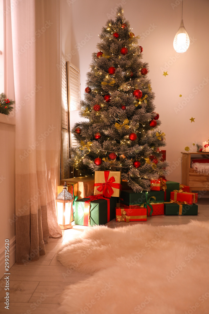 Stylish room interior with beautiful Christmas tree and gift boxes