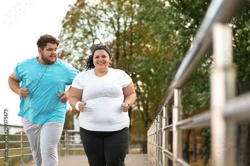 Obraz na płótnie Overweight couple running together in park