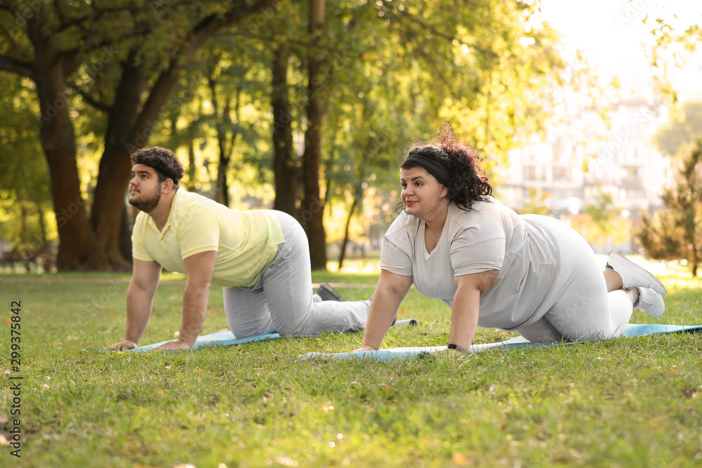 Fototapeta premium Overweight couple training together in park on sunny day