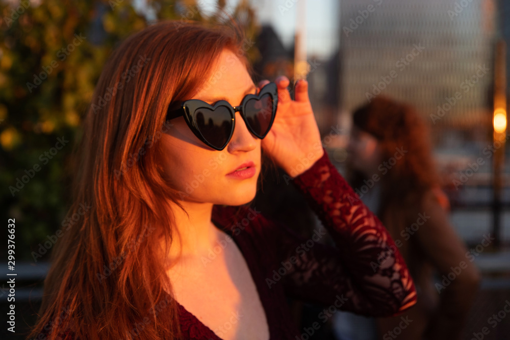 Woman with red hair wearing sunglasses Woman with red hair wearing sunglasses