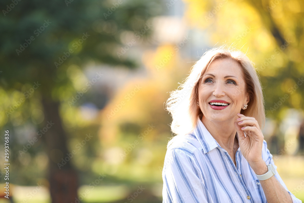 Portrait of happy mature woman in park on sunny day Portrait of happy mature woman in park on sunny day