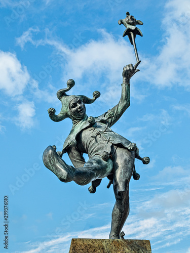 фотографія Court Jester statue in Stratford-upon-Avon against a bright blue sky