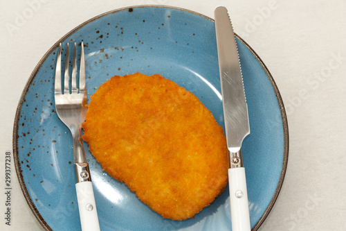 Tasty vegetarian schnitzel on a blue plate. Plant based meat.