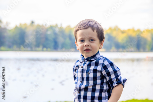 Portrait of a boy in a shirt on the street. Beautiful boy. Little boy. Walk. A child's smile.