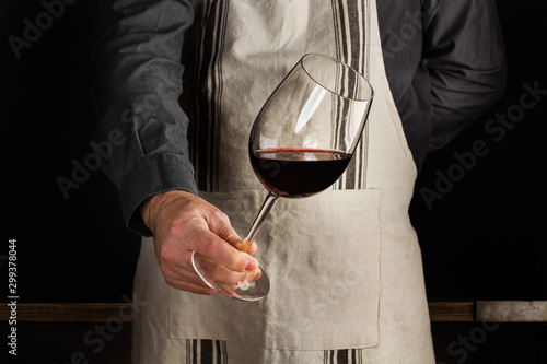 Fotografia Hombre camarero sosteniendo una copa de vino tinto en movimiento