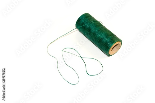 Spool of green waxed thread. Isolated background