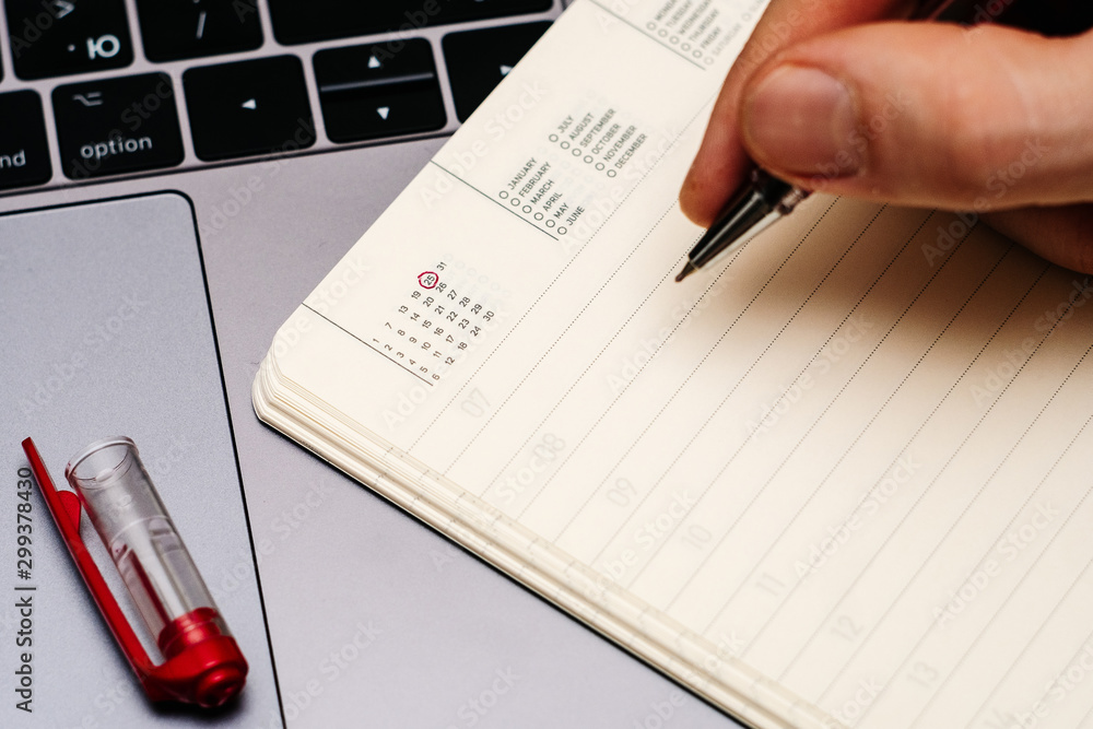 male hand encircles date 25 (twenty five) in the diary calendar. male hand encircles date 25 (twenty five) in the diary calendar.
