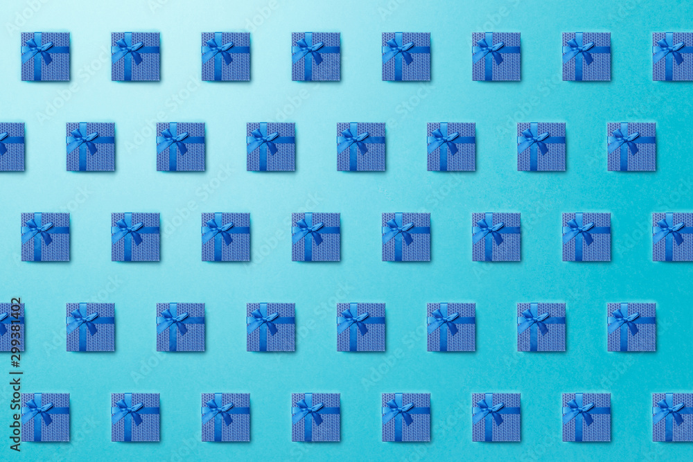 Trendy pattern made with Blue gift boxes on bright light blue background. Minimal christmas new year creative concept. Minimal style with colorful paper backdrop