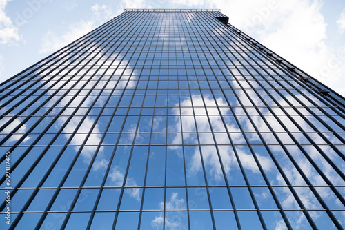 Ground view of tall business centre reflecting blue sky