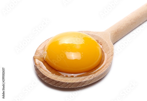 Raw egg with yolks in wooden spoon isolated on white background