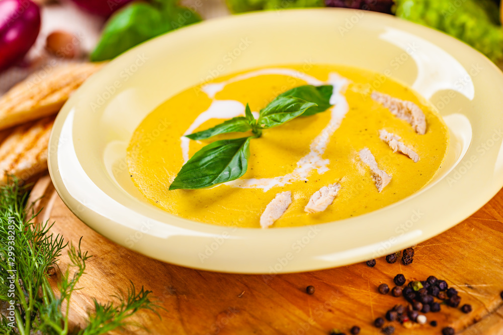 Cheese cream soup with chicken on wooden board Cheese cream soup with chicken on wooden board