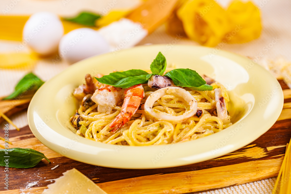 Spaghetti with seafood and parmesan cheese in beige plate Spaghetti with seafood and parmesan cheese in beige plate