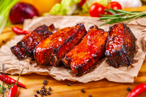 Grilled barbecue pork ribs with spices and herbs on wooden board