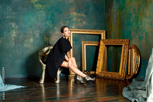 beauty rich brunette woman in luxury interior near empty frames, wearing fashion clothes, lifestyle pretty real people concept