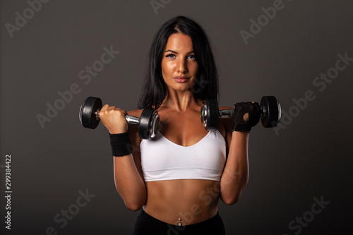 Attractive sexy fitness girl with weights on her hands