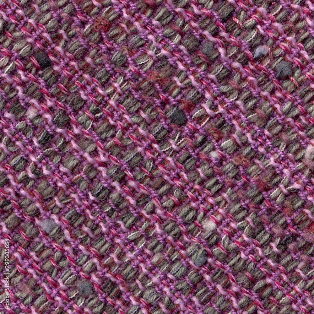 Close-up detail of handwoven woolen patterned fabric in pink and gray