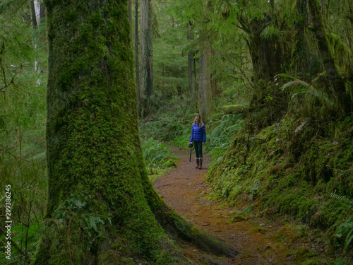 CLOSE UP: Cheerful young woman treks along a scenic trail in Hoh Rainforest.