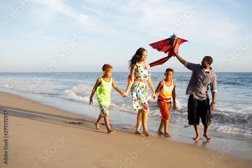 happy family at the beach flying a kite