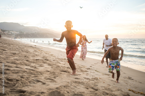 Family playing at the beach at sunset