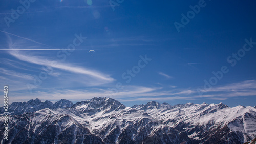 Paragliding over Alps with mountain cliffs covered with snow in Karnten Austria.