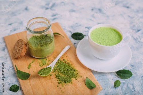  White cups with matcha and powder for its preparation.