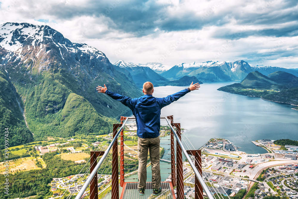 man enjoys the view with his hands raised - obrazy, fototapety, plakaty 