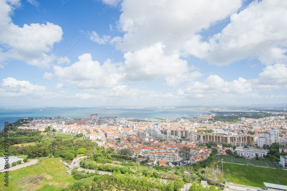 Panoramic view of the Tagus river and the buildings of Almada , this picture was captured from the National Sanctuary of Christ the King  statue in Lisbon , Portugal . 
