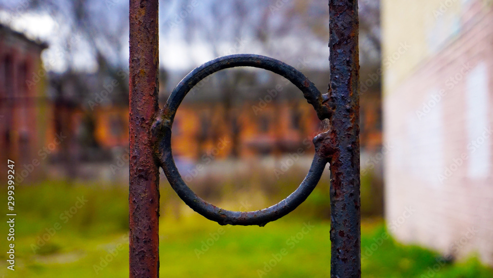rusty metal ring on a fence against the background of old houses Stock  Photo | Adobe Stock