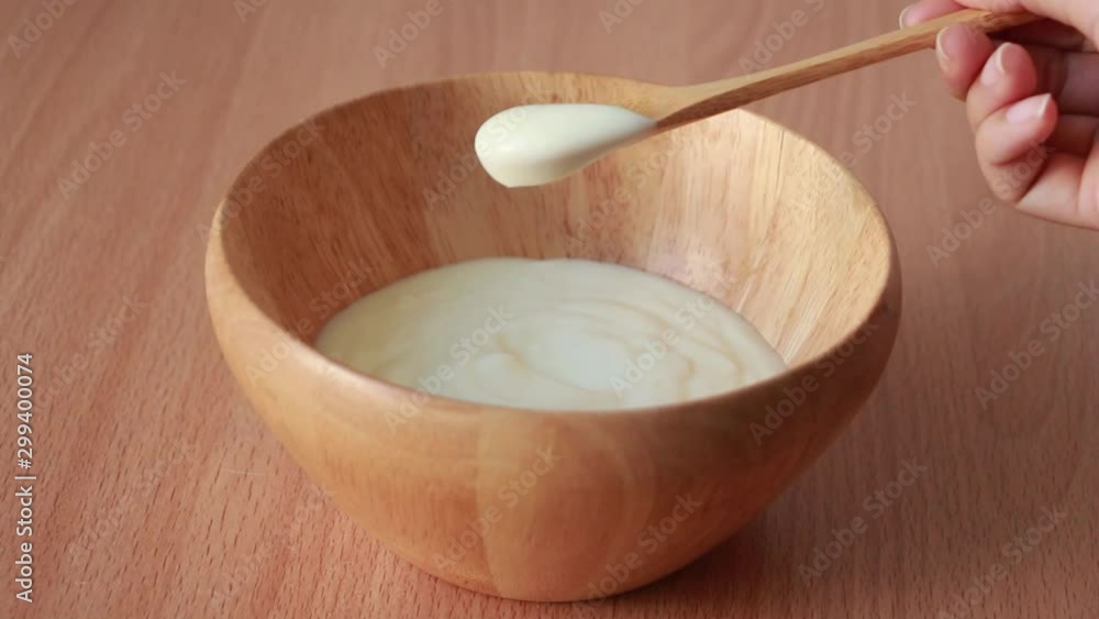 eating organic yogurt with spoon from wood bowl eating organic yogurt with spoon from wood bowl