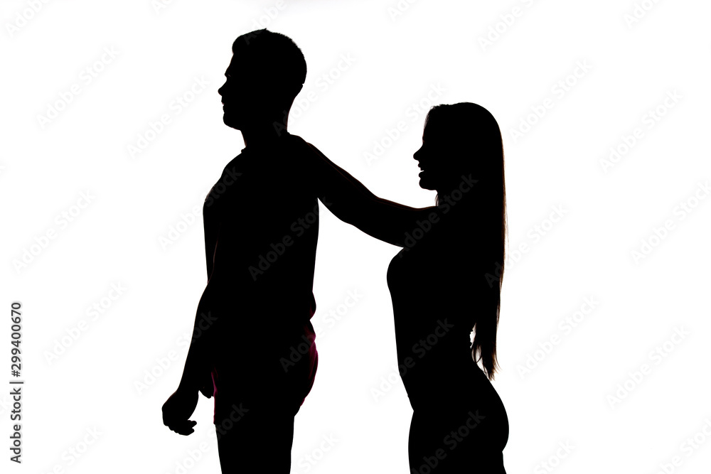 Foto de Perfiles de dos personas, un hombre y una mujer; la mujer le da un  masaje en la espalda para curar el dolor que padece; do Stock
