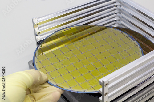 Silicon Wafers in steel holder box take out by hand in gloves A wafer is a thin slice of semiconductor material, such as a crystalline silicon, used in electronics for the fabrication of integrated  photo