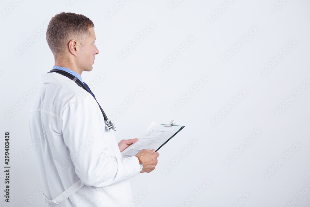 Male doctor standing with folder, isolated on white background Male doctor standing with folder, isolated on white background