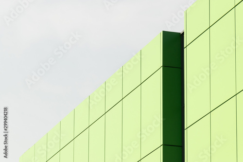 Geometric color elements of the building facade with planes, lines, corners with highlights and reflections for the abstract background and texture of green, light green, blue colors. Place for text